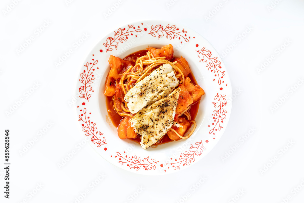 close up of spaghetti with baked fish in tomato sauce