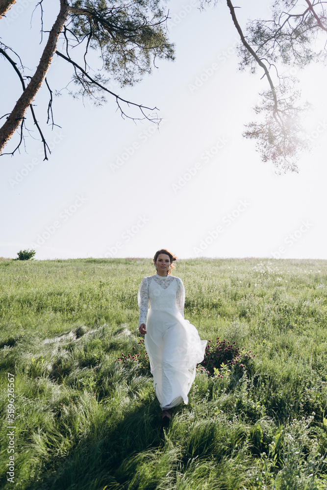 bride in white dress standing in green area bride in white dress standing in green area