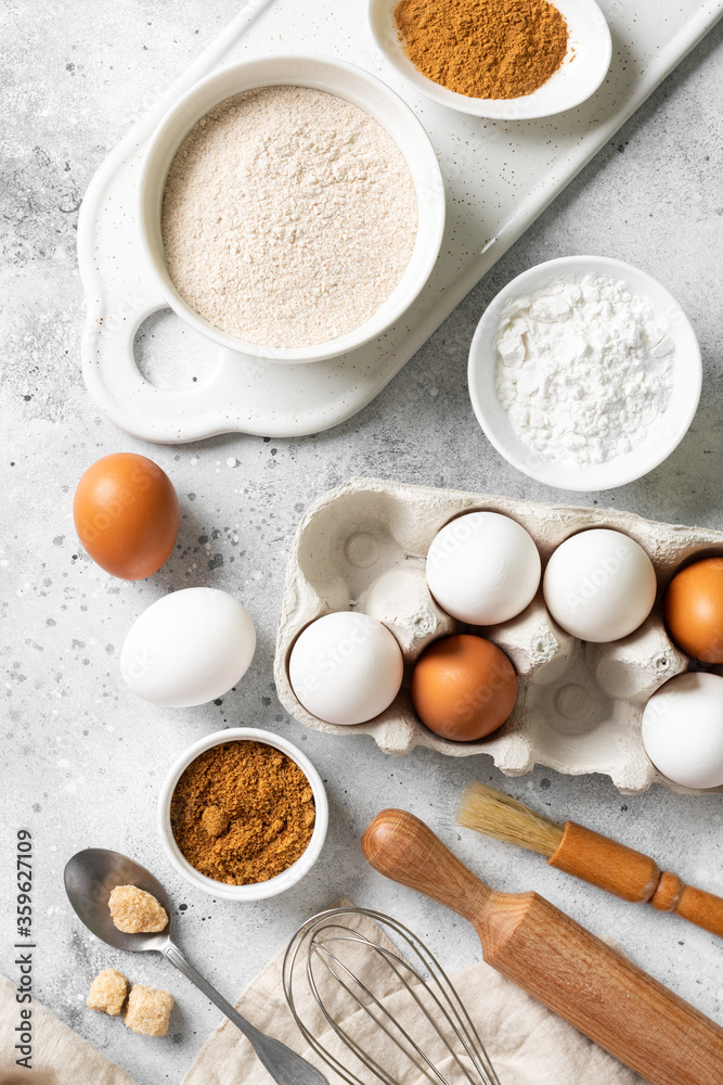 Ingredients for baking on a culinary background. Eggs, flour, cinnamon, sugar, soda on the kitchen table. Concept of preparation for baking Ingredients for baking on a culinary background. Eggs, flour, cinnamon, sugar, soda on the kitchen table. Concept of preparation for baking