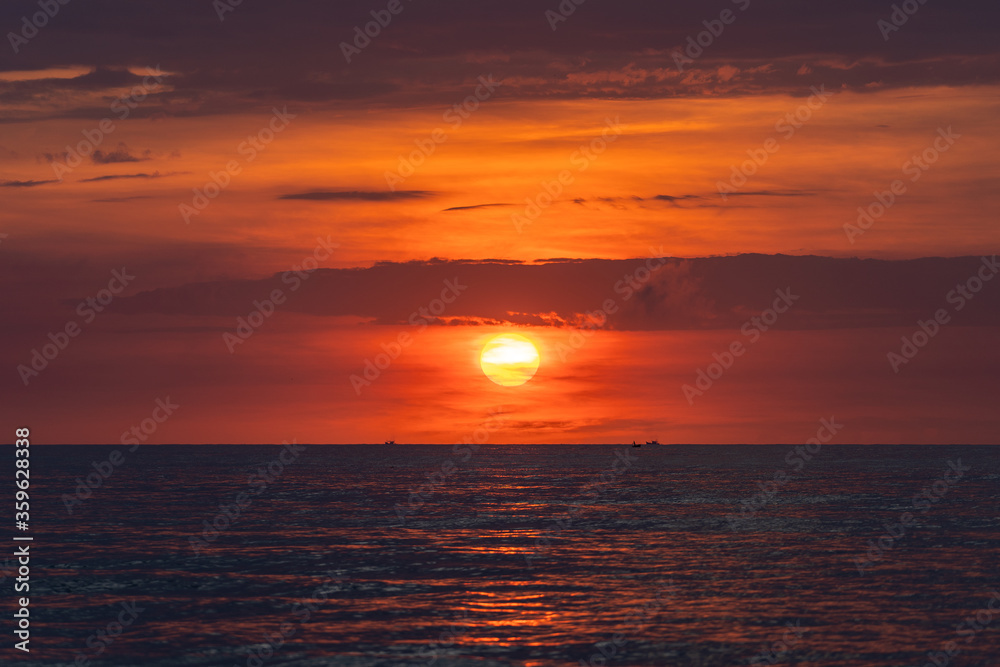 Landscape sunrise on the beach in sea, Vietnam. Travel and nature concept. Morning red sky, clouds, sun and sea water