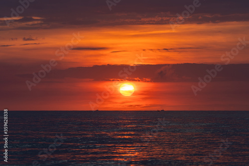 Landscape sunrise on the beach in sea, Vietnam. Travel and nature concept. Morning red sky, clouds, sun and sea water