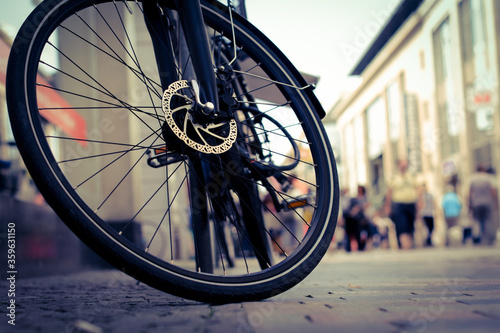 Close up of front bike wheel and blur background street at the city 