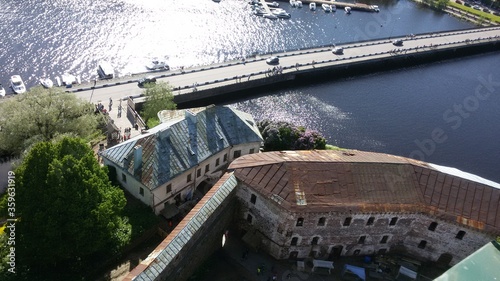 The road leading through the lake and pier with two old buildings: Vyborg