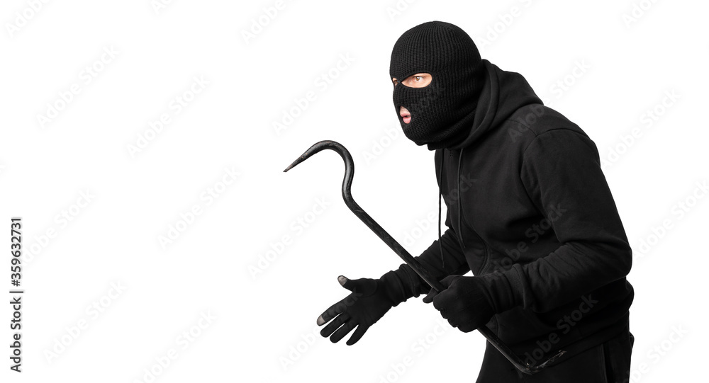 Thief wearing black mask and hoodie looking at copyspace Thief wearing black mask and hoodie looking at copyspace