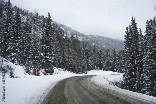 Road in winter mountains. Cloudy weather.