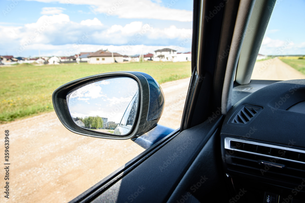 Dirty side rear-view mirror on a modern car.