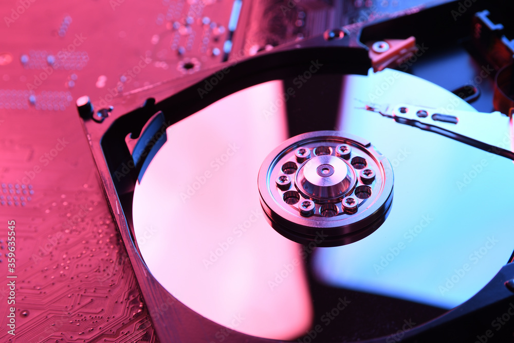 Computer Hard disk drives HDD , SSD on circuit board ,motherboard background. Close-up. With red-blue lighting Computer Hard disk drives HDD , SSD on circuit board ,motherboard background. Close-up. With red-blue lighting