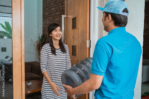 Canvas-taulu man courier delivering gallon of water to customer