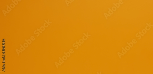 Karton pomarańczowo żółty stanowiący tło.