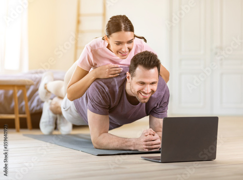 Man Doing Plank With Girlfriend Lying On Him Indoor