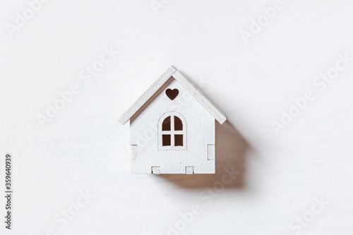Simply minimal design with miniature toy house isolated on white background. Mortgage property insurance dream home concept. Flat lay top view, copy space