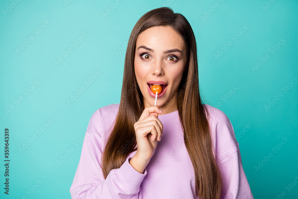 Photo of pretty funny lady hold lollipop hands good mood sweets addicted person lick bite tasty candy wear violet pullover isolated vibrant teal color background Photo of pretty funny lady hold lollipop hands good mood sweets addicted person lick bite tasty candy wear violet pullover isolated vibrant teal color background