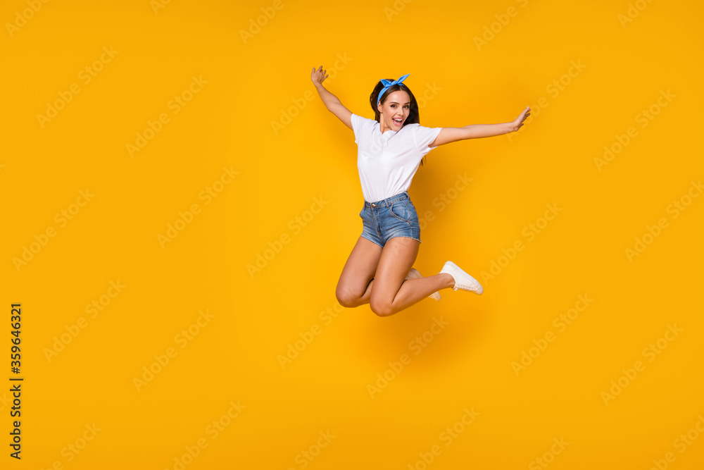 Full size photo of dreamy lovely cute excited girl jump raise hands enjoy spring free time weekend holiday wear good look blue headband sneakers isolated over bright color background