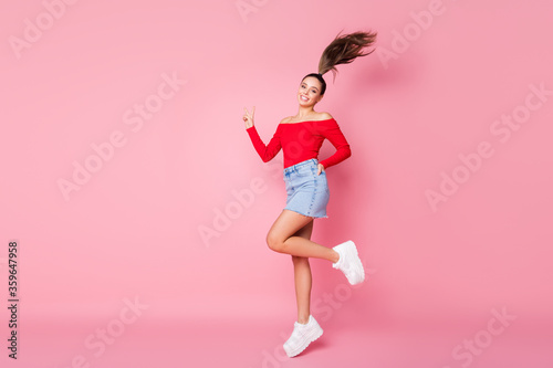 Full length body size view of her she nice-looking attractive lovely pretty slender cheerful cheery girl having fun jumping showing v-sign isolated over pink pastel color background