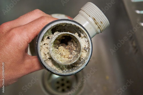 Cuadro en lienzo clogged sink pipe,in the hands of a clogged dirty sewer pipe from leftover food