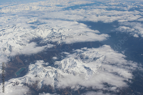 Widok z samolotu na góry Alpejskie. Śnieg na górach gór. Widok na Jezioro i alpejskie miasteczka.