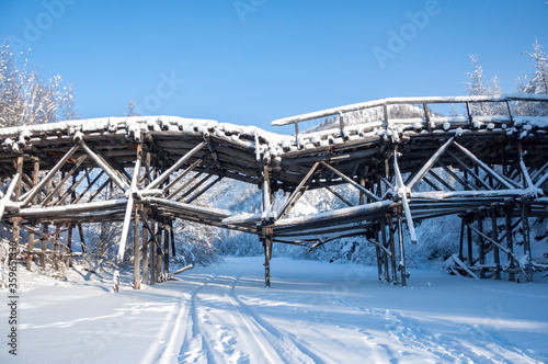 Ruins of wooden bridge, built by prisoners of labour camp GULAG in Verkhoyansk Range in Yakutia during cold winter day, Russia. The construction of the Kolyma highway aka Road of bones