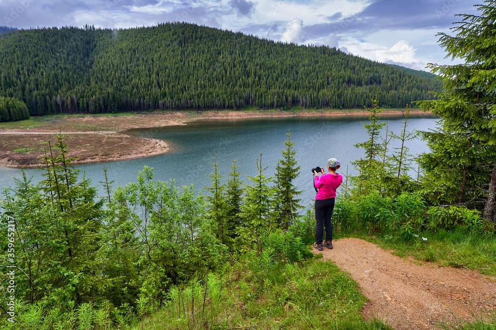 Tourist with camera taking photos in the mountains Tourist with camera taking photos in the mountains