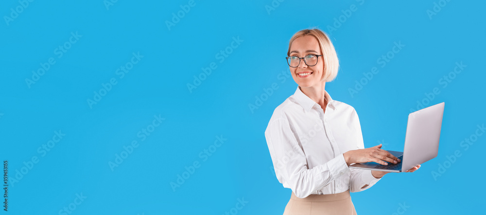 Happy millennial business lady with modern laptop on blue background, space for text - obrazy, fototapety, plakaty 