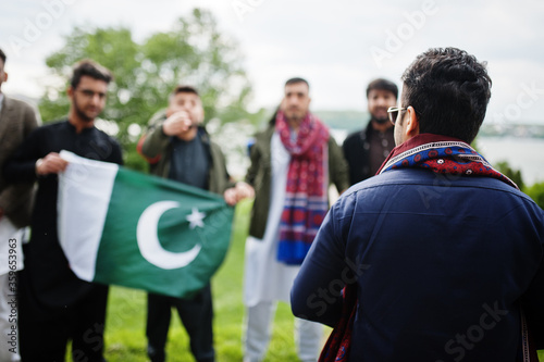 Group of pakistani man wearing traditional clothes salwar kameez or kurta with Pakistan flags.