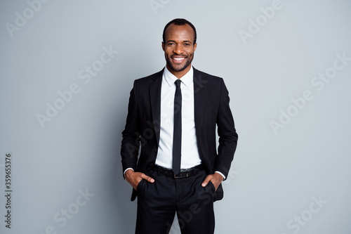 Portrait of his he nice attractive cheerful cheery guy employee banker financier wearing fashionable brandy suit holding hands in pockets posing isolated over grey pastel color background