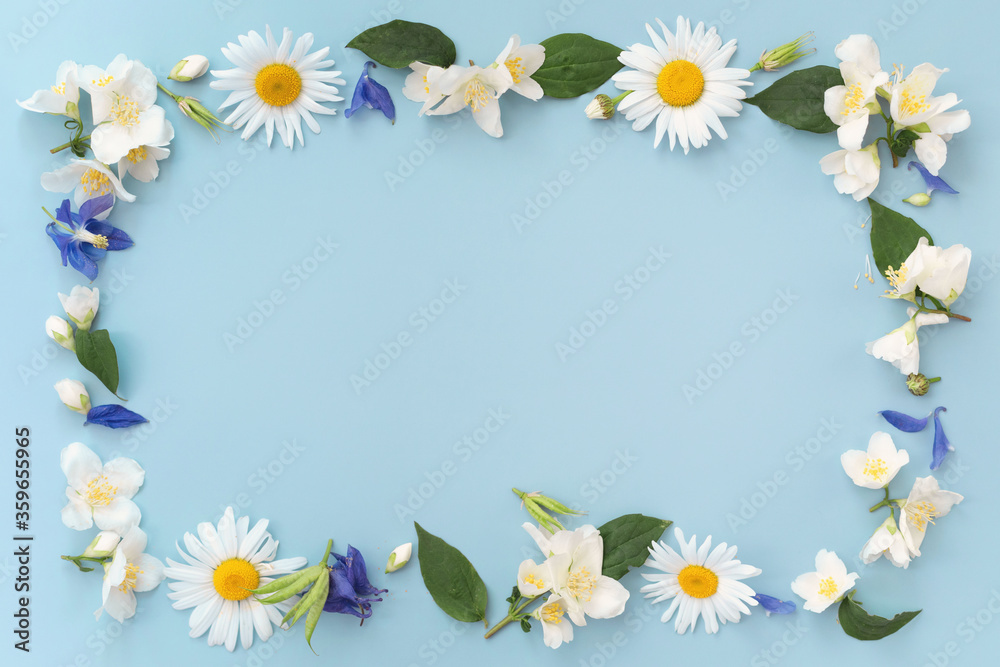 Floral composition. Frame made of various colorful flowers on light blue background. Easter, spring, summer concept. Flat lay, top view, copy space for text.