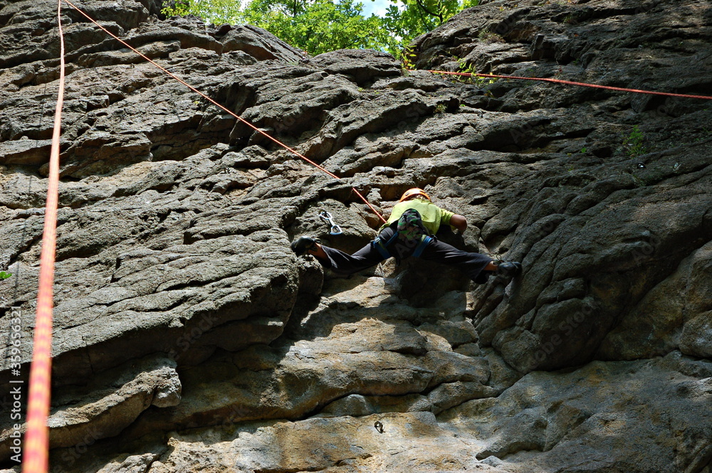 little boy climbs on the rock with rope little boy climbs on the rock with rope