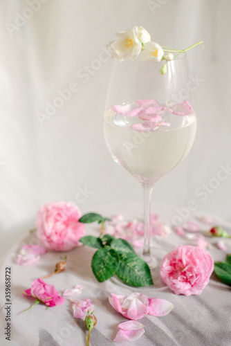 Glass with water and roses on the table