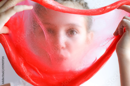 Bright pink slime in girl's hands. Education, creativity, childhood concept. Selective focus.