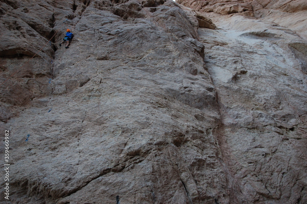 little boy climbs on the rock with rope little boy climbs on the rock with rope