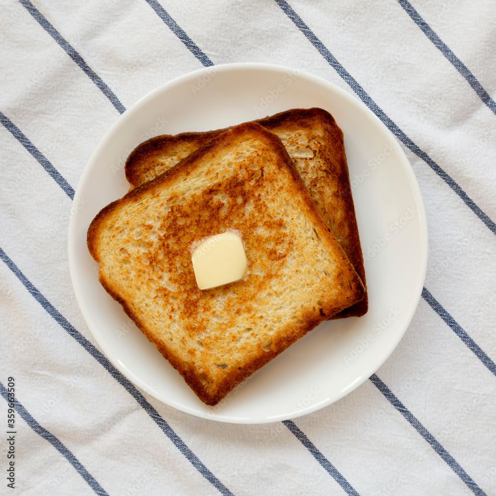 Homemade Buttered Toast on a white plate, top view. Flat lay, overhead, from above.