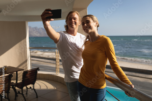 Caucasian couple taking selfie on a balcony during quarantine lockdown for coronavirus Covid19 pande photo