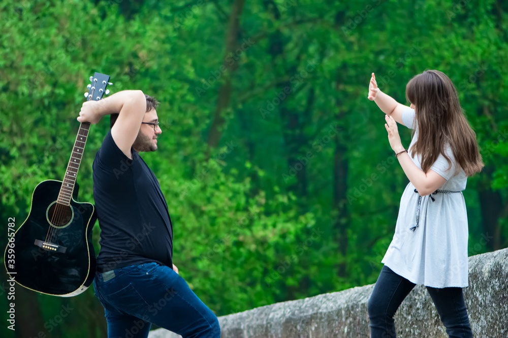 Man hitting the woman by guitar outdoor Man hitting the woman by guitar outdoor