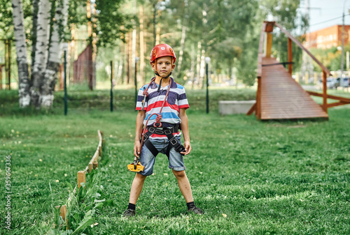 Boy with climbing gear standing in rope park