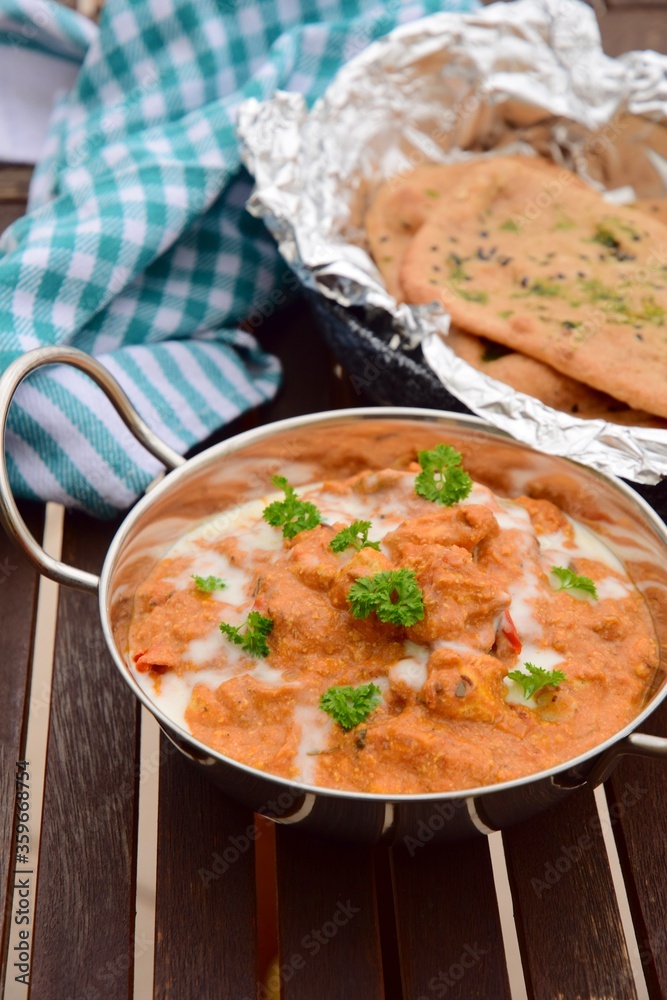 Murgh Makhani or butter chicken served with homemade whole wheat garlic Naan bread Murgh Makhani or butter chicken served with homemade whole wheat garlic Naan bread