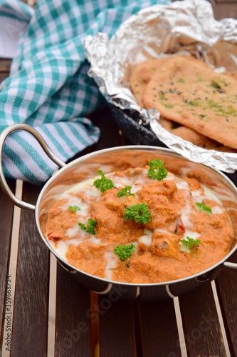 Murgh Makhani or butter chicken served with homemade whole wheat garlic Naan bread