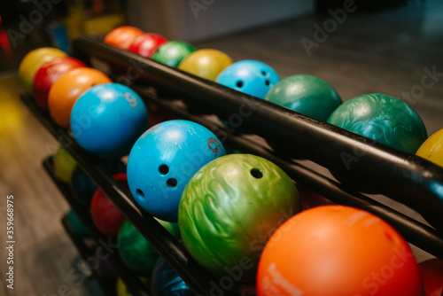 Multicolored bowling balls on the shelf in the bowling club