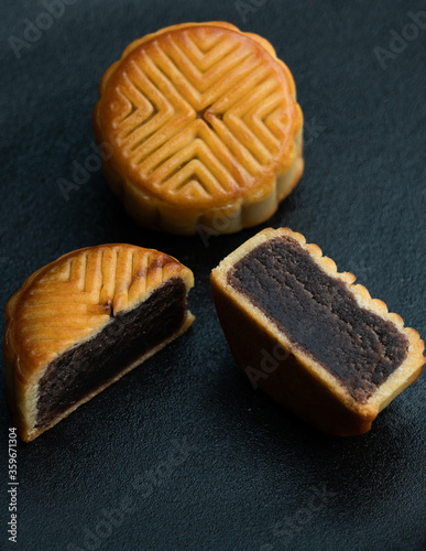 Moon cakes cut by mid autumn festival are placed on a black backgroundMoon cakes cut by mid autumn festival are placed on a black background photo