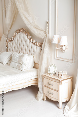 Elegant bedside and sconce. Luxury interior in white colors