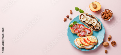 Sweet sandwiches with fruits and berries on pink colorful background.