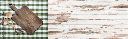 Empty cutting board and tablecloth on wooden deck table with napkin photo