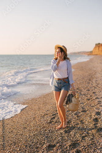 Young beautiful woman posing on summer beach. © polinaloves