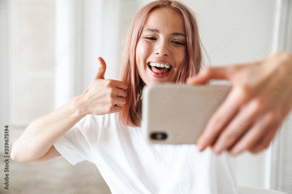 Cheerful young girl taking a selfie indoors Cheerful young girl taking a selfie indoors