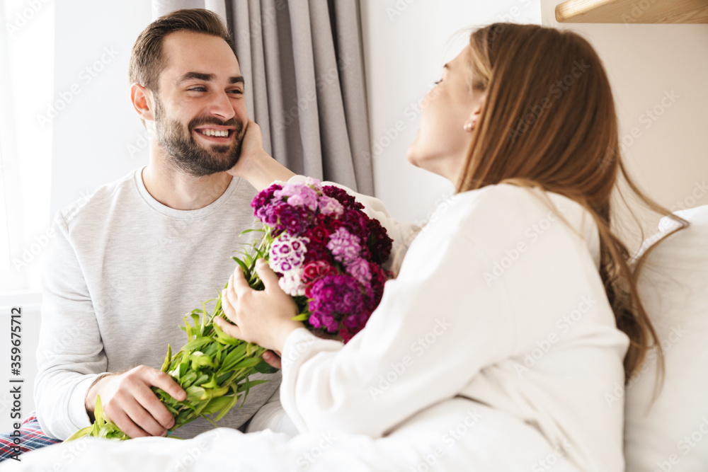 Happy man giving his lovely girlfriend bouquet of flowers Happy man giving his lovely girlfriend bouquet of flowers
