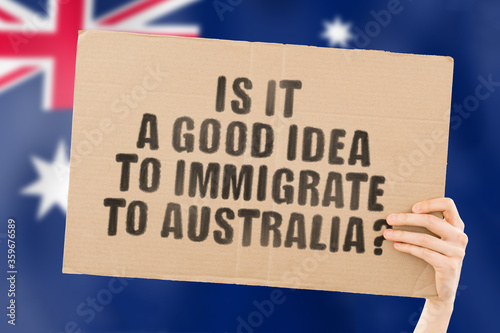 Canvas-taulu The question  Is it a good idea to immigrate to Australia?  on a banner in men's hand with blurred Australian flag on the background