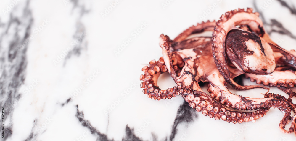 Naklejka premium Close up picture of an octopus on a marble table. White space for design or text
