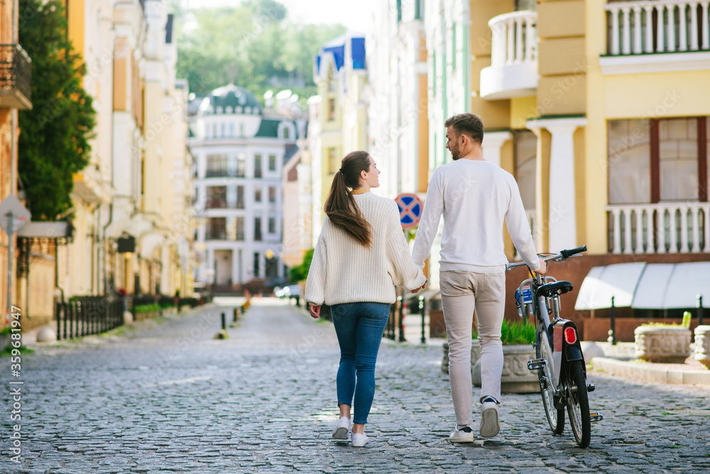 Naklejka premium Woman and man with bike walking looking at each other