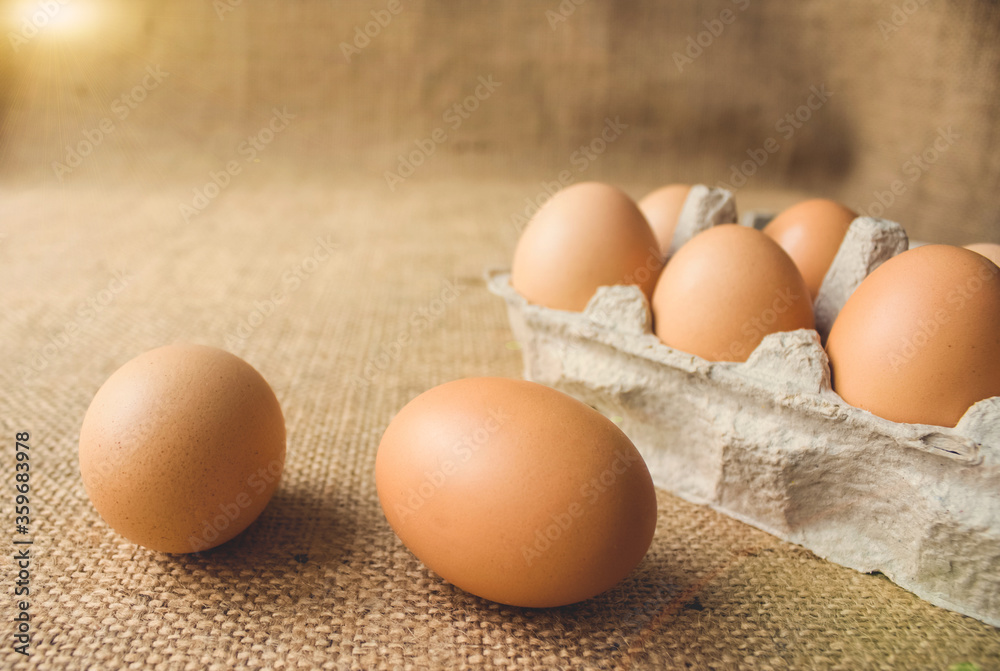 Front view on fresh organic chicken eggs from local farmer market in paper packaging box standing on the table, in sunny day. Healthy organic food concept. Copyspace for your text or presentation Front view on fresh organic chicken eggs from local farmer market in paper packaging box standing on the table, in sunny day. Healthy organic food concept. Copyspace for your text or presentation