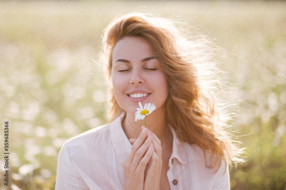 Young beautiful woman relaxing in chamomile field. Young beautiful woman relaxing in chamomile field.