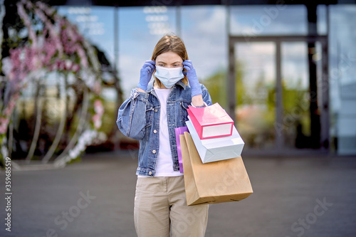 Girl takes off a used medical mask. Shopping during a pandemic.